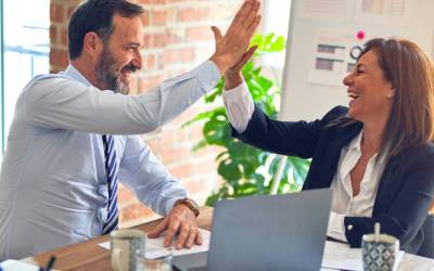 Deux experts souriants célèbrent le succès d'un accompagnement en digitalisation d'entreprise avec la solution Pennylane.